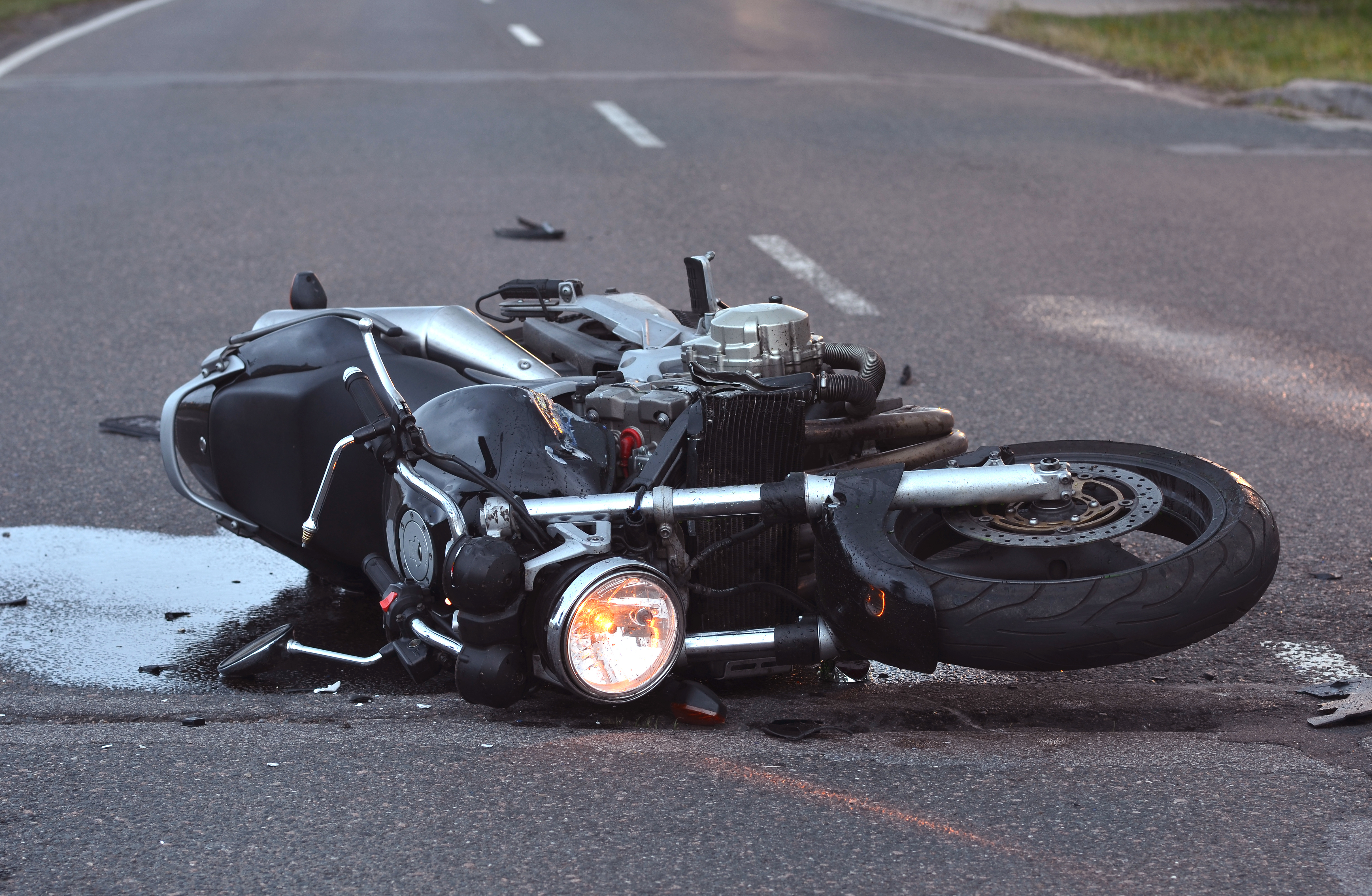  Ein schwarzes Motorrad liegt auf der Straße nach einem Motorrad Unfall. Ein Gutachter für Motorräder muss den Schaden begutachten. 